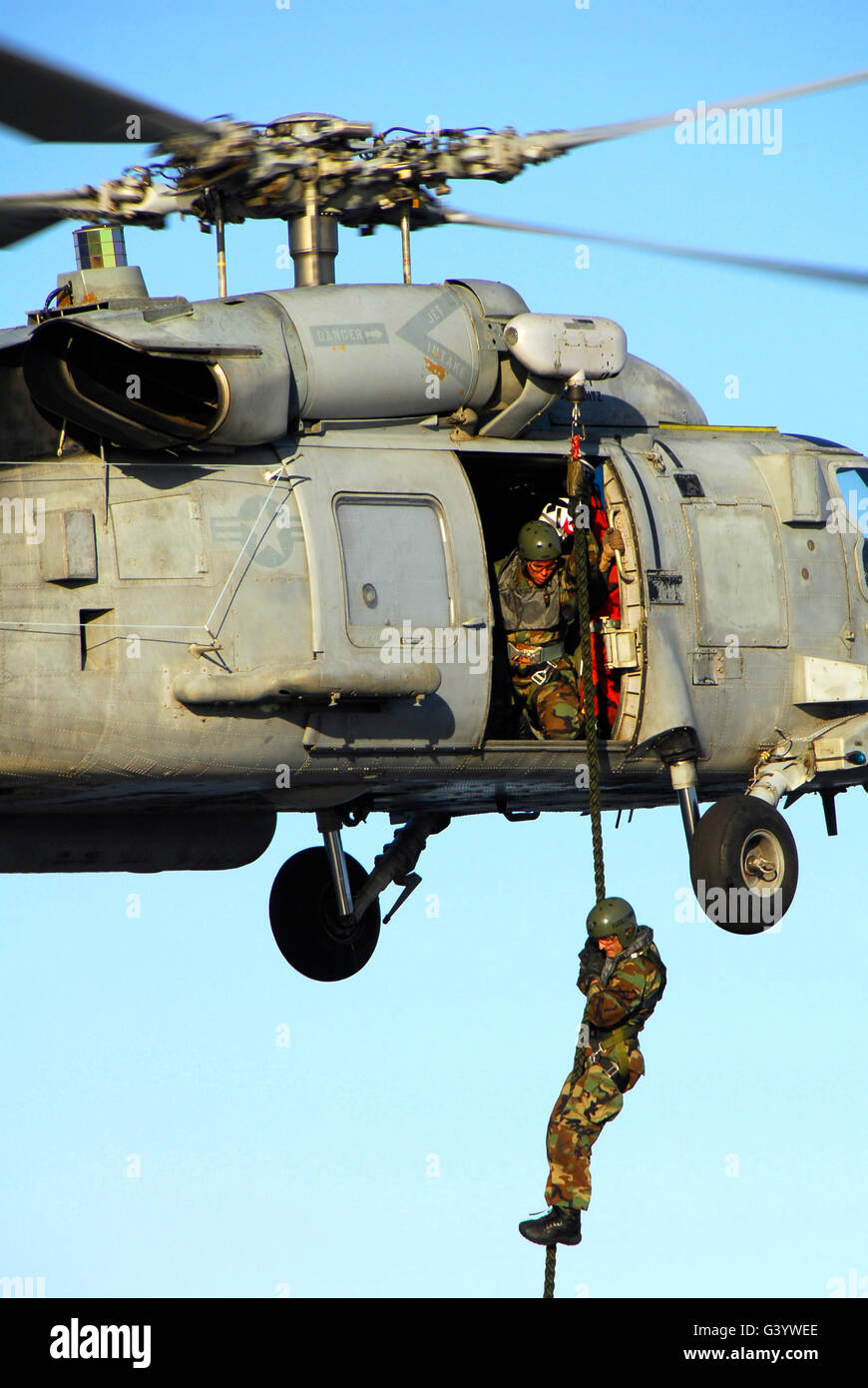 Soldier fast ropes from an SH-60 Seahawk. Stock Photo