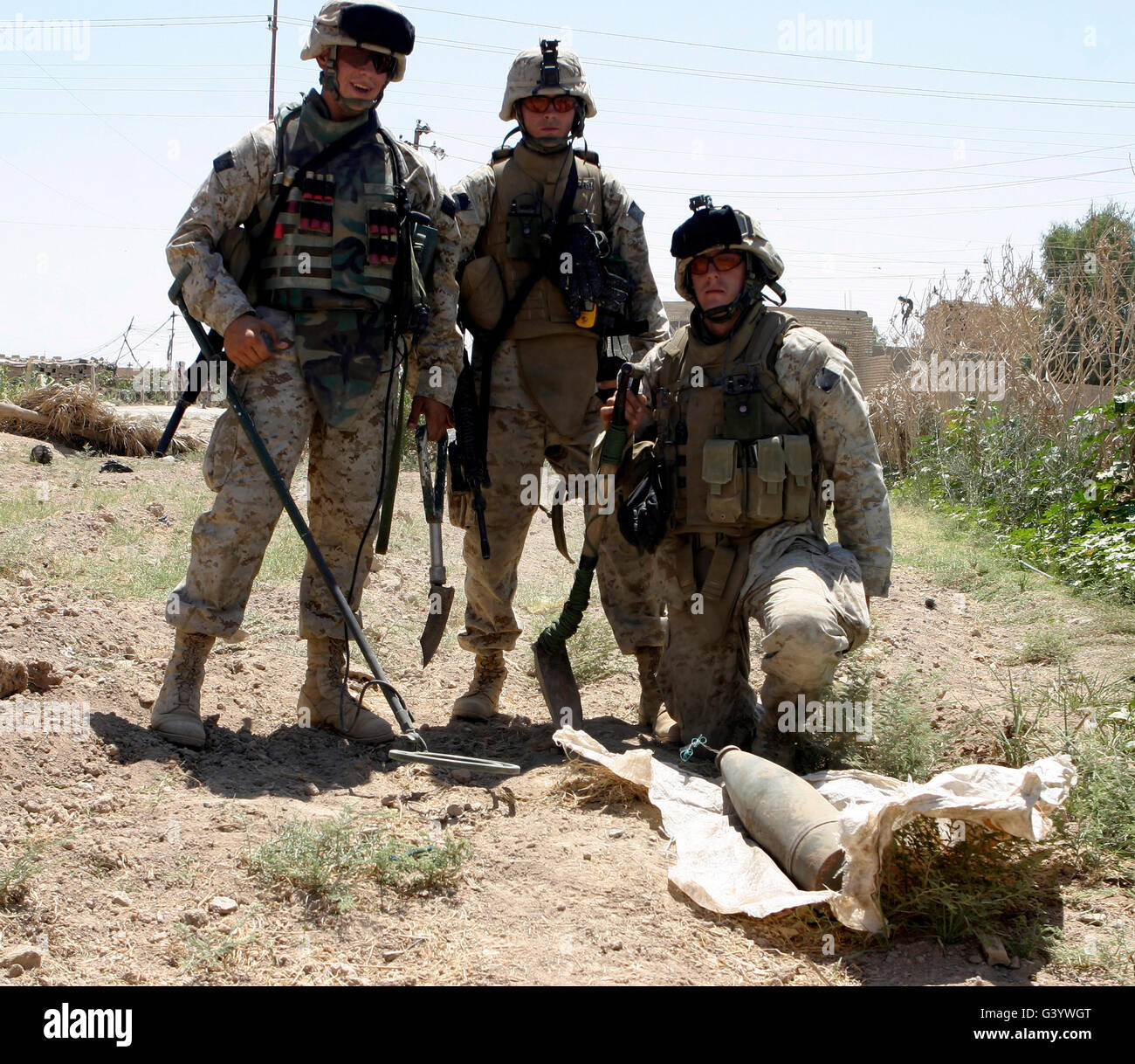 Combat engineers stand behind an unearthed improvised explosive device. Stock Photo