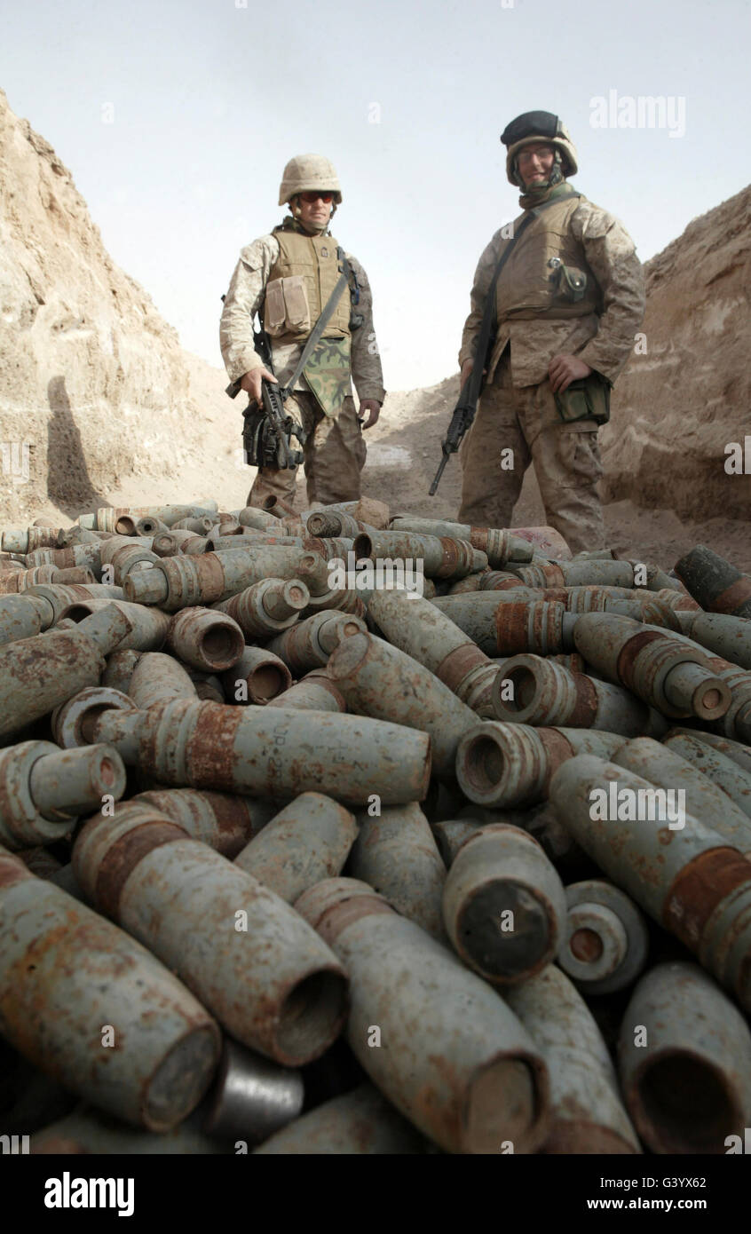 Marines stand over a pile of unused ordnance. Stock Photo