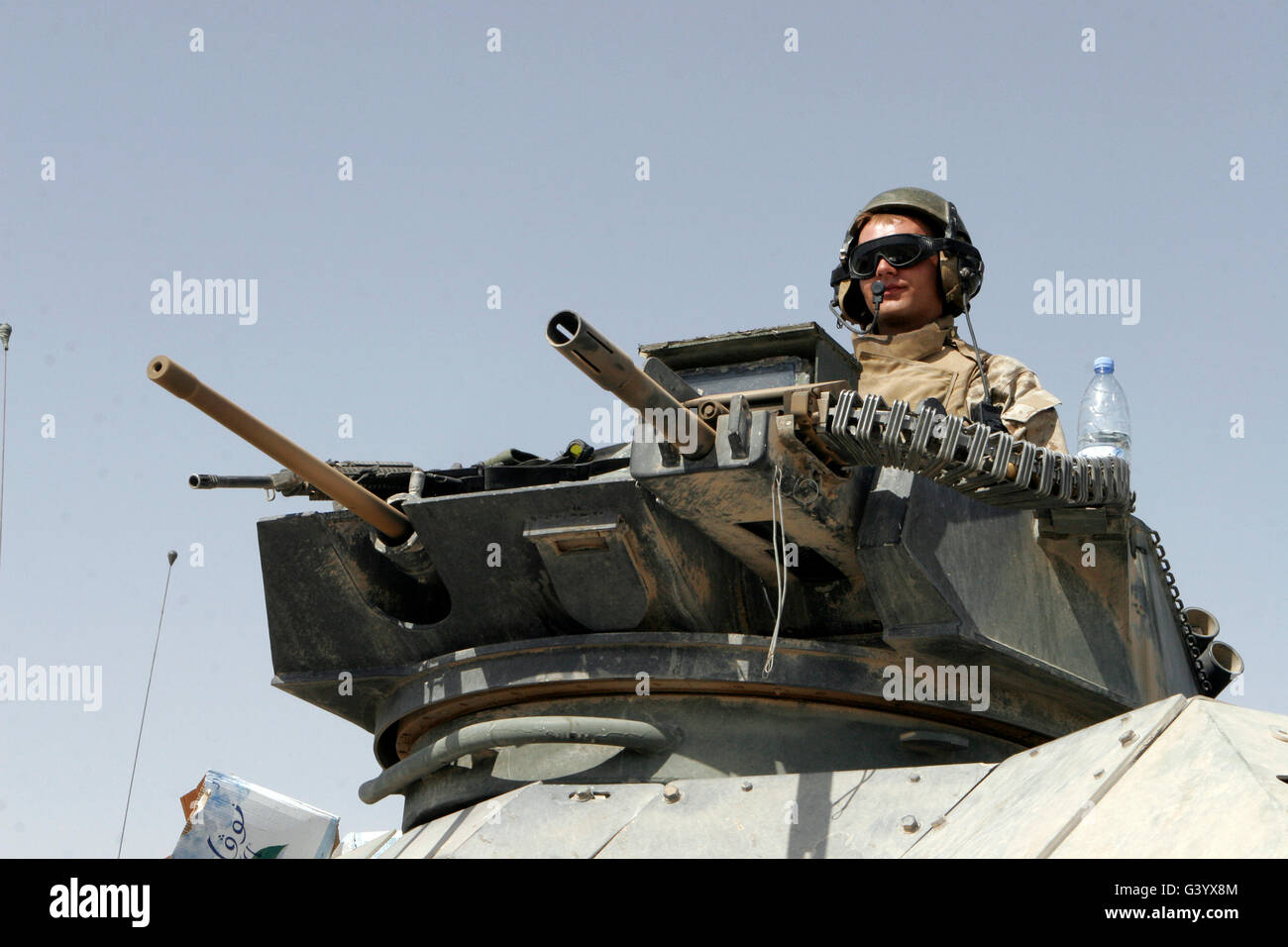 A crewman mans a heavy machine gun and grenade launcher from his vehicle Stock Photo