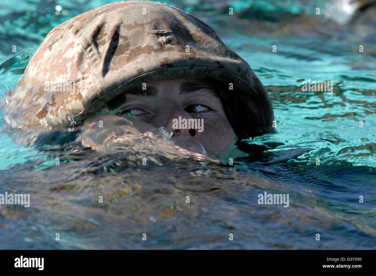 A U.S. Marine swims across a training tank pool. Stock Photo