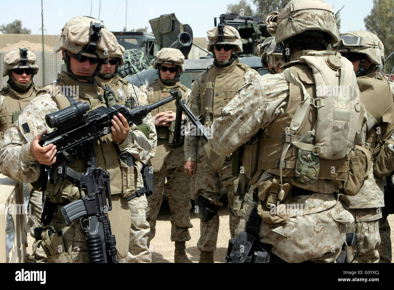 Vehicle commander shows fellow Marines how to properly clean their