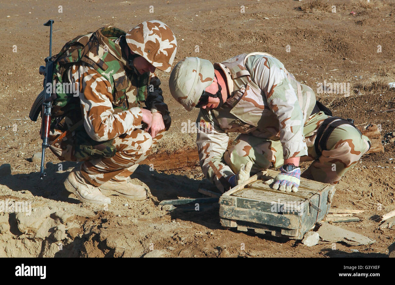 Army soldiers look for information on a case of ammunition. Stock Photo