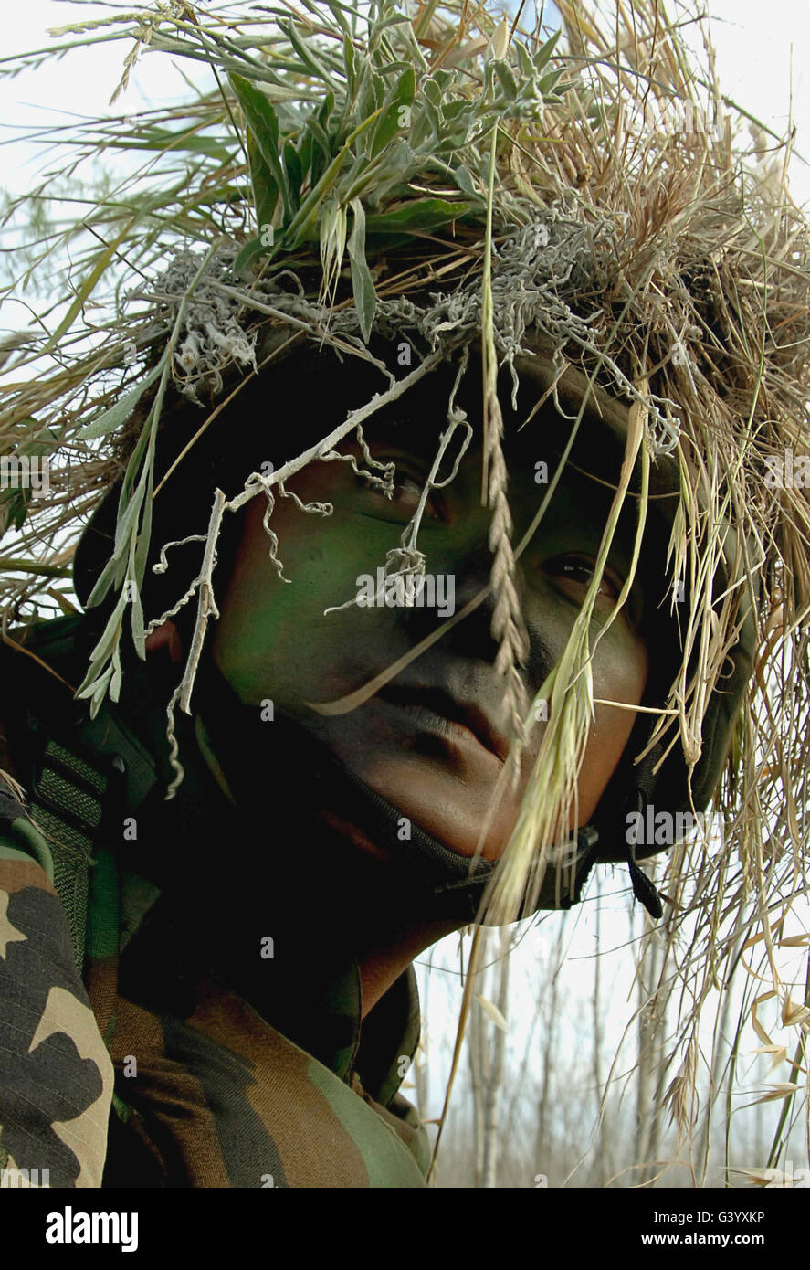 Airman wearing a ghillie suit and camouflage face paint. Stock Photo