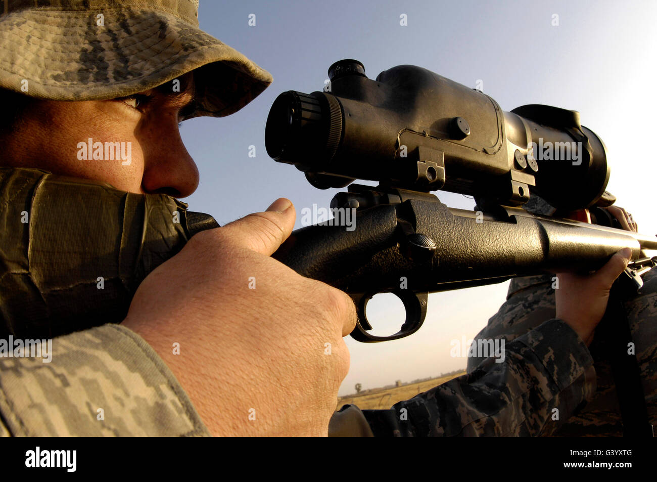 An airman slowly squeezes the trigger of his M-24 sniper rifle. Stock Photo