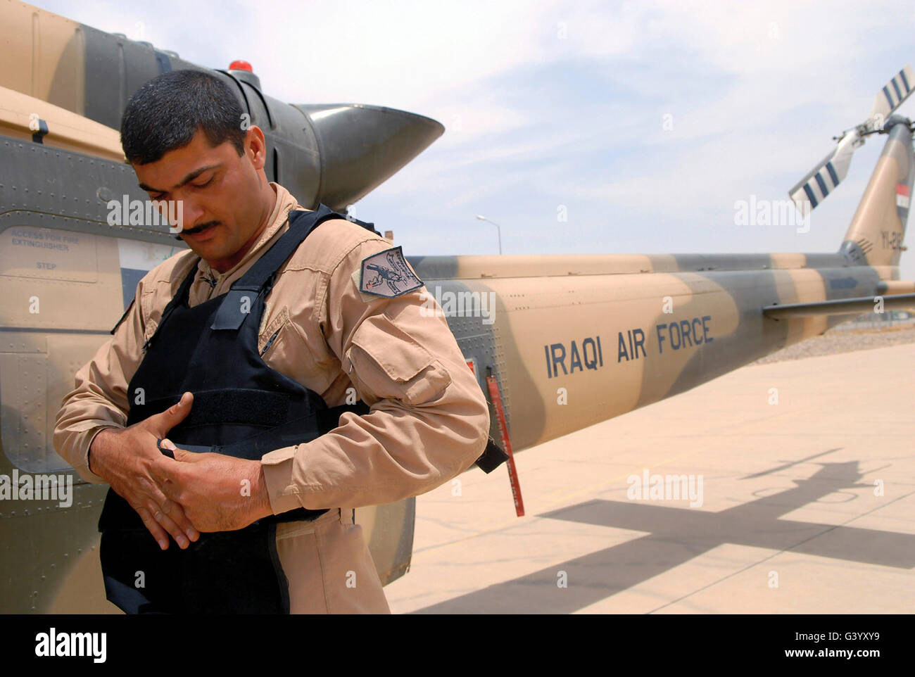 An Iraqi air force aerial gunner putting on his body armor. Stock Photo