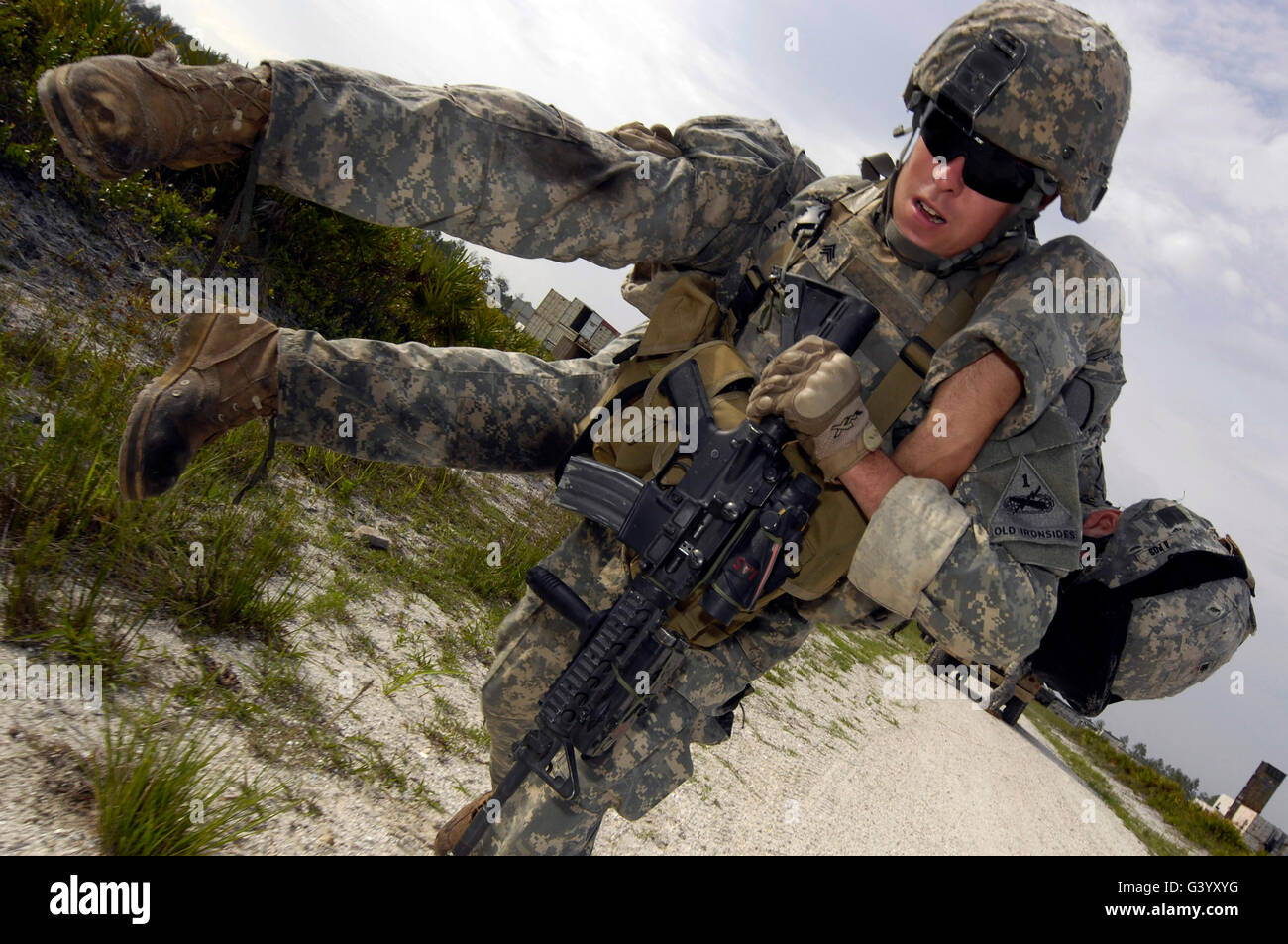 A soldier carries a wounded soldier to safety. Stock Photo