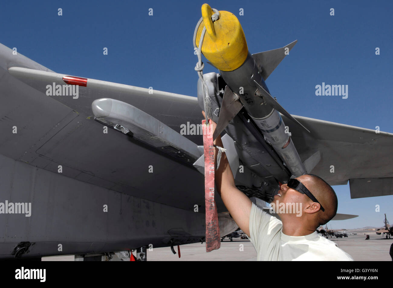 A weapons expediter inspects an AIM-9 missile on a F-15 aircraft. Stock Photo
