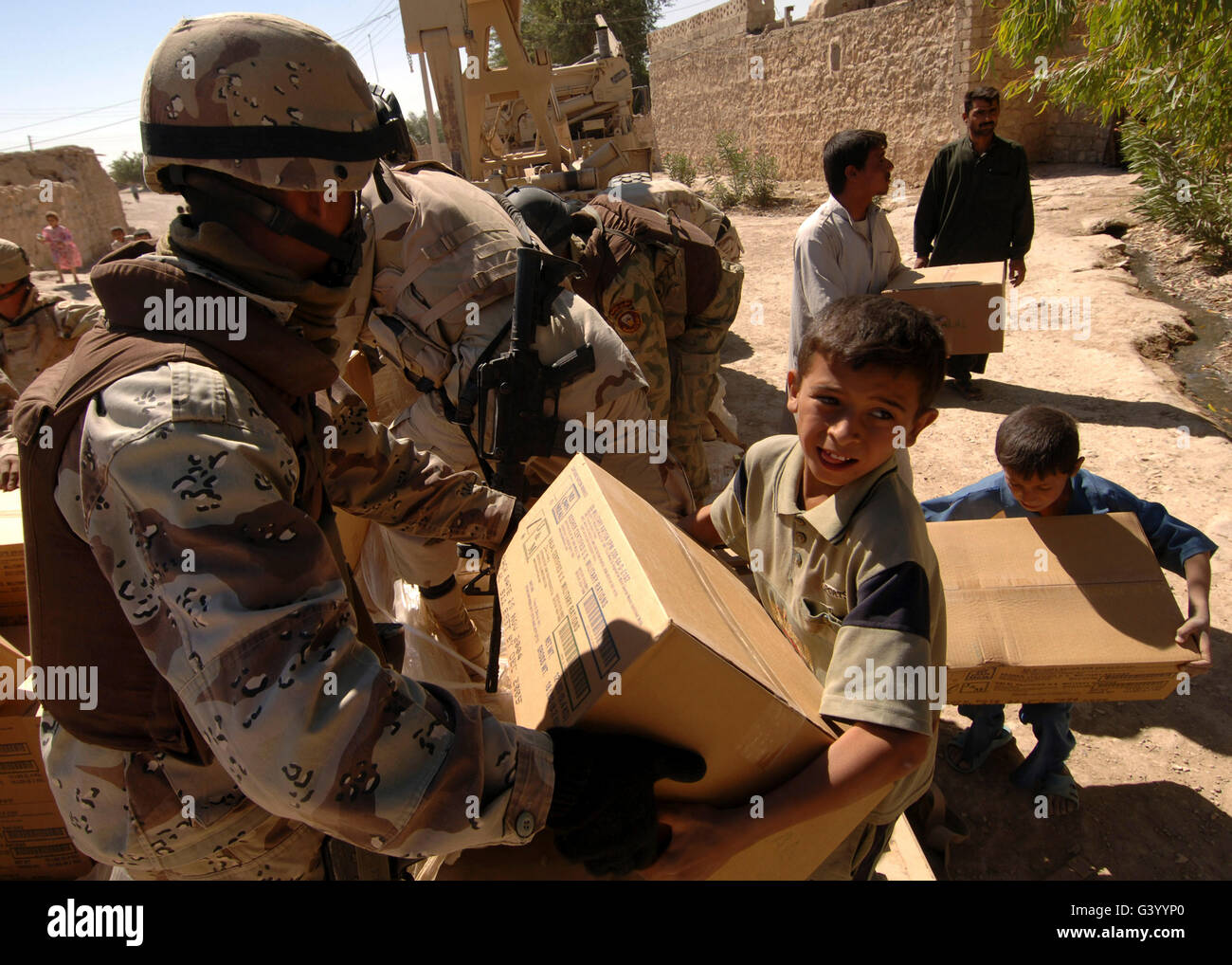 An Iraqi Army soldier handing a box of food to a boy of the Choloq ...