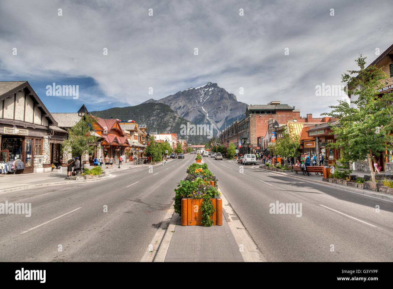 Banff, Canada - July 3, 2014: Shoppers stroll along the many retail shops along Banff Avenue in the Banff National Park. The tow Stock Photo