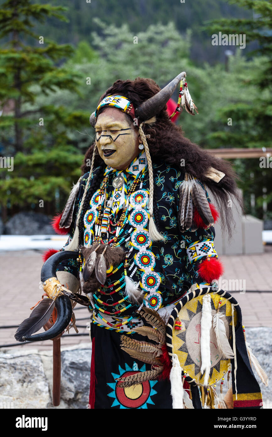 BANFF, CANADA- JUL 3, 2014: A native Blackfoot indian chief wearing a split-horn bonnet dances at a performance in Banff. Stock Photo