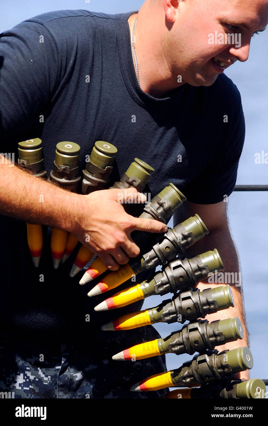 Gunner's Mate downloading an ammo belt from an MK 38 25mm gun on USS Fort McHenry. Stock Photo