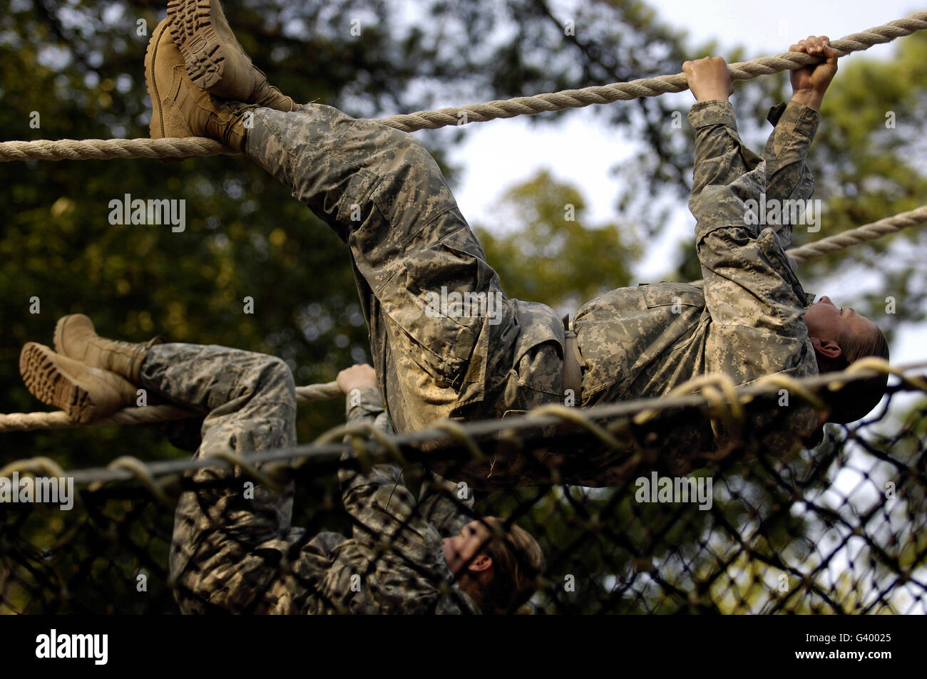 U.S. Army recruits shuffling down a rope obstacle during basic combat training at Fort Jackson, South Carolina. Stock Photo