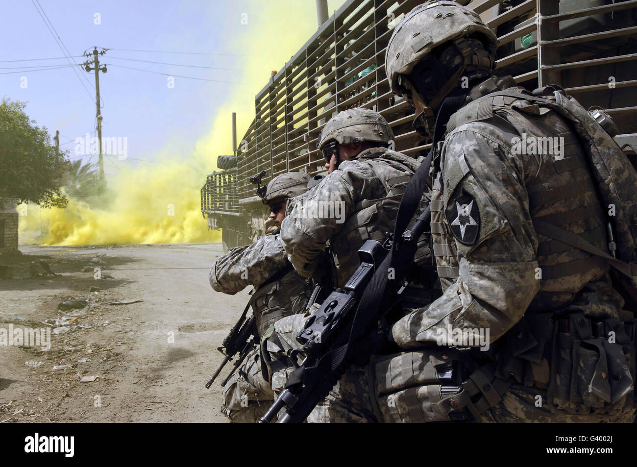 U.S. Army soldiers using smoke grenades for concealment as they engage anti-Iraqi forces in Buhriz, Iraq. Stock Photo