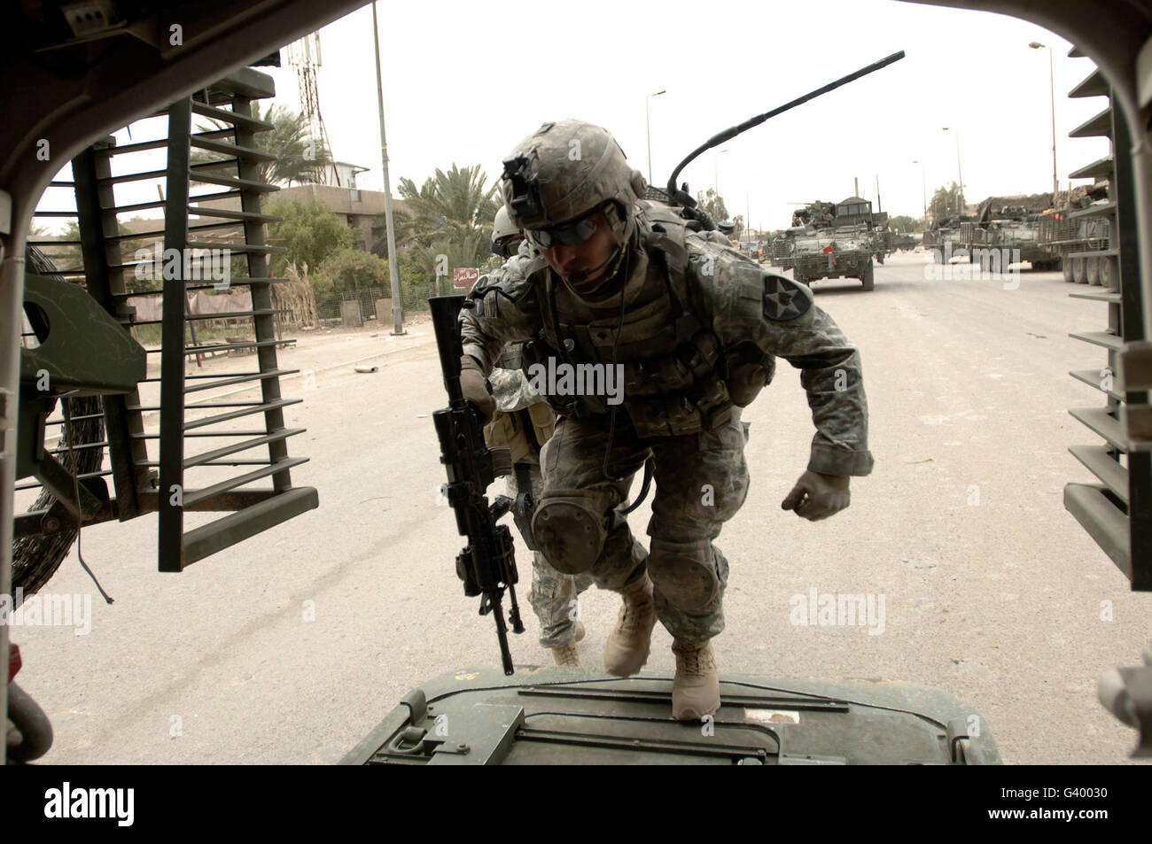 U.S. Army Specialist entering a Stryker assault vehicle in Baghdad, Iraq. Stock Photo
