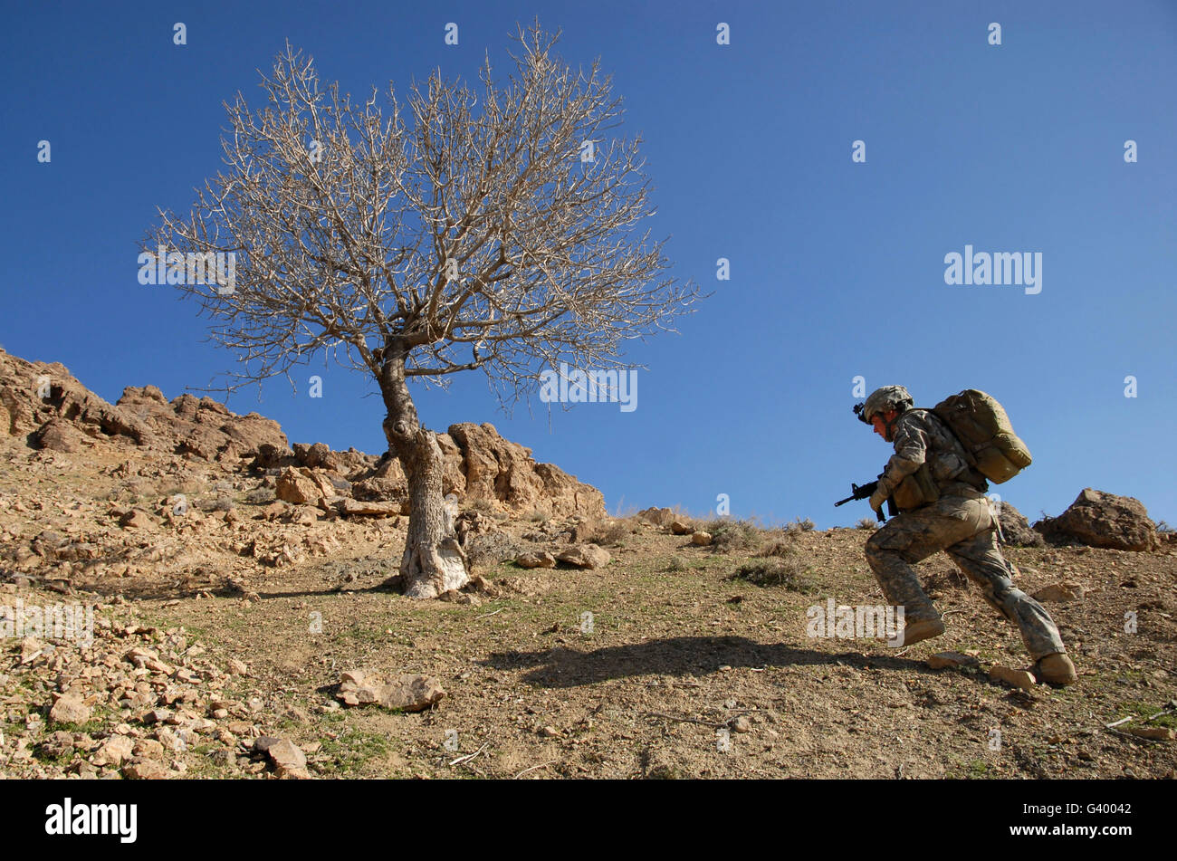 U.S. Army soldier climbing a mountain ridge during a dismounted patrol in the Zabul province of Afghanistan. Stock Photo