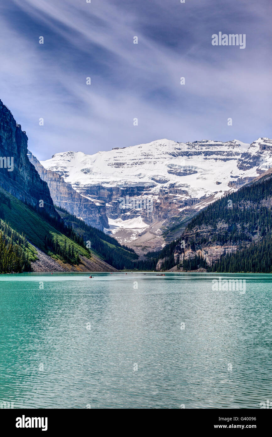 A breathtaking view of Mt Victoria glacier on Lake Louise in the Canadian Rockies, with several canoes visible on the lake. Stock Photo