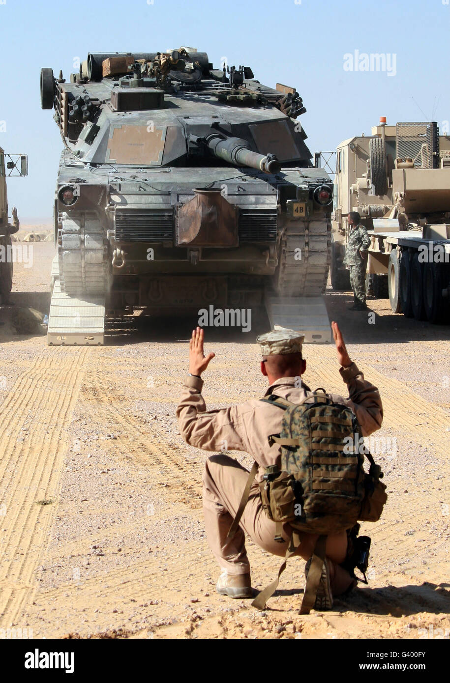 A Marine guides an M1-A1 Abrams Main Battle Tank off a transport trailer. Stock Photo