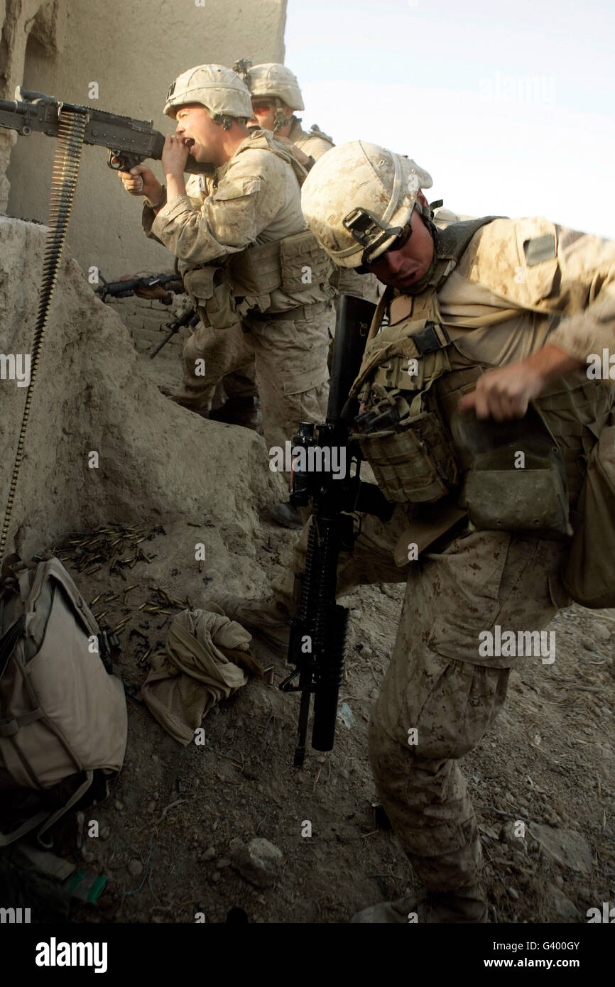 A U.S. Marine reaches for more rounds during combat. Stock Photo