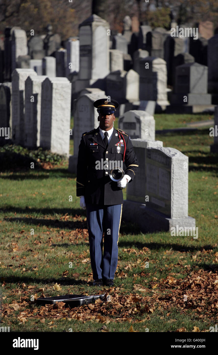 An Army soldier stands in the Cypress Hills National Cemetery waiting to play taps. Stock Photo