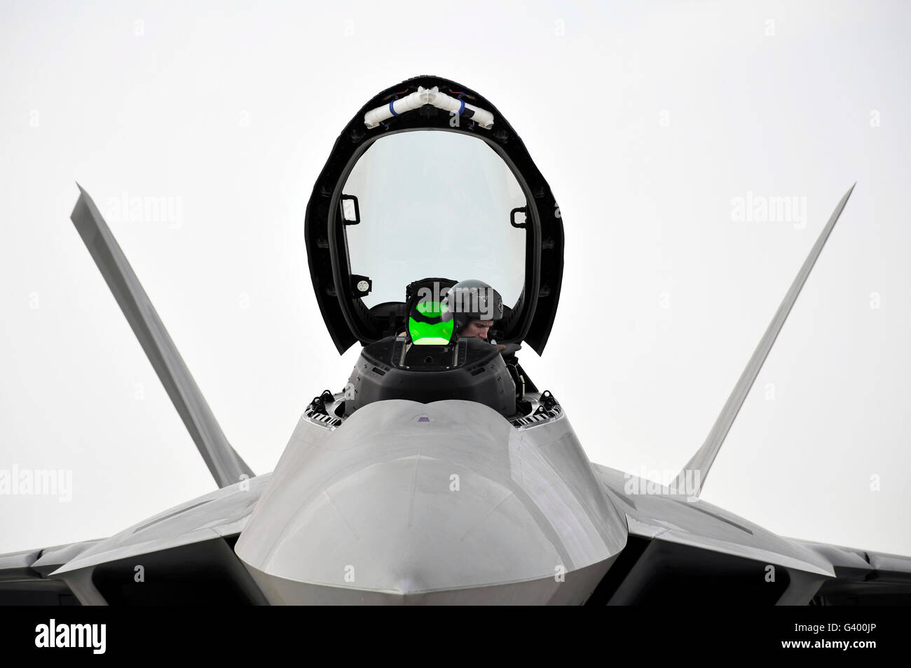 A pilot checks the cockpit of an F-22 Raptor before closing the canopy. Stock Photo