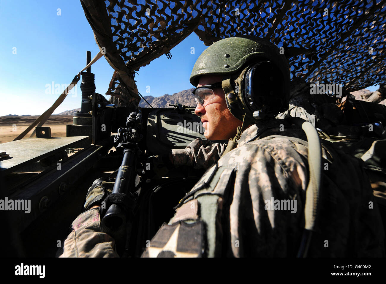 U.S. Army soldier mans the air guard position inside a Stryker armored vehicle. Stock Photo