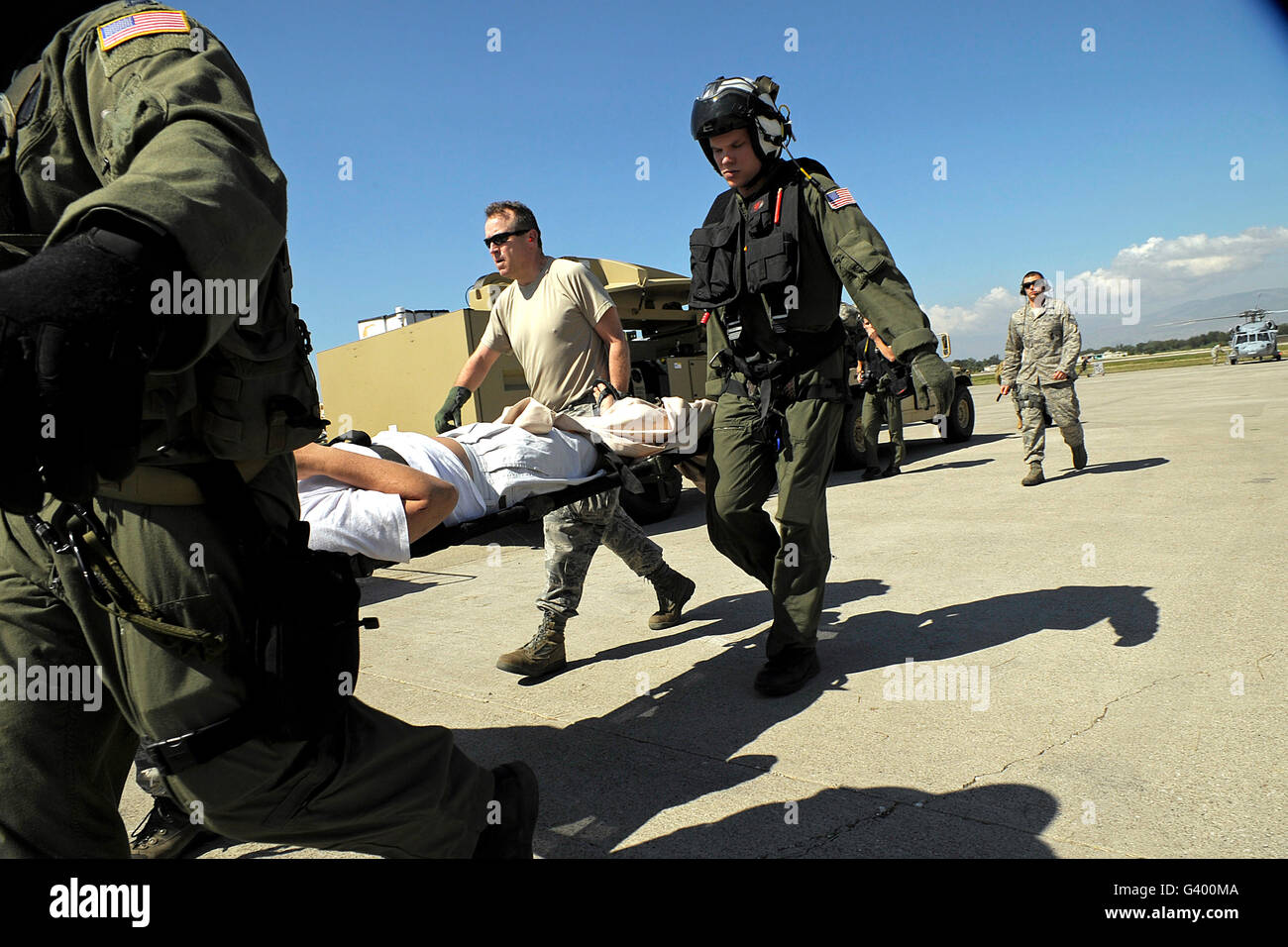 U.S. Airmen offload injured people from a C-130 Hercules aircraft. Stock Photo
