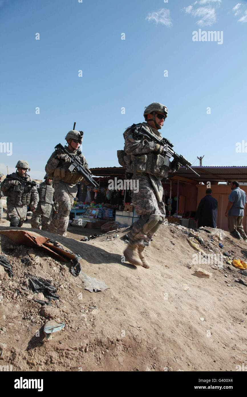 U.S. Army soldiers walk through a market in Ebnkathwer, Iraq. Stock Photo
