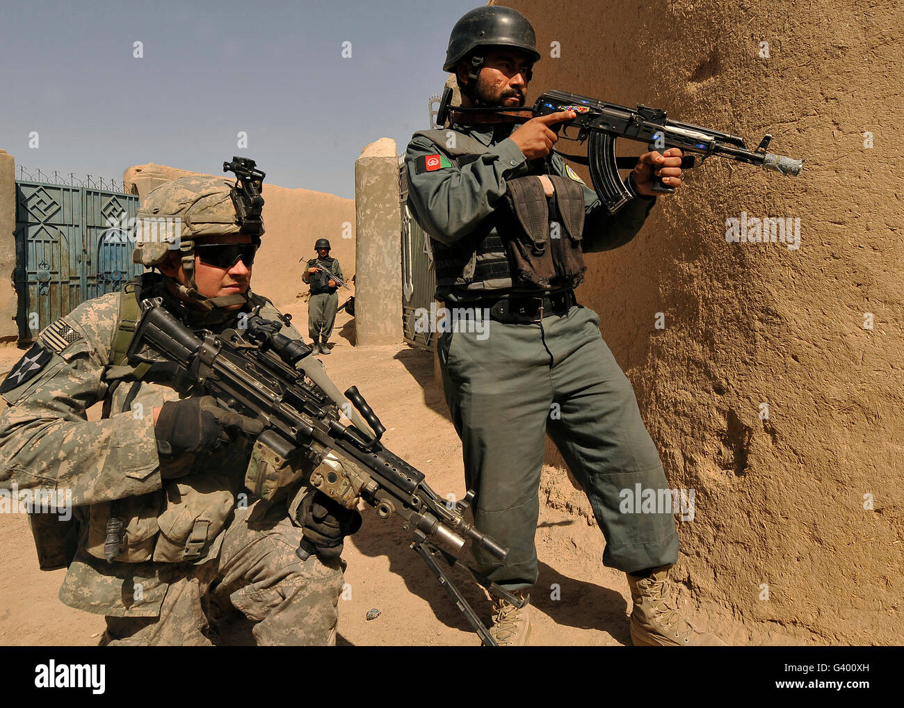 U.S. Army soldier and an Afghan National Policeman provide security during a joint patrol. Stock Photo