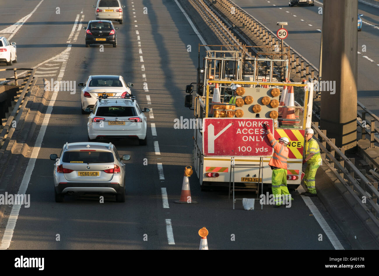 Workers erecting road traffic sign on urban motorway,Glasgow,Scotland,UK, Stock Photo
