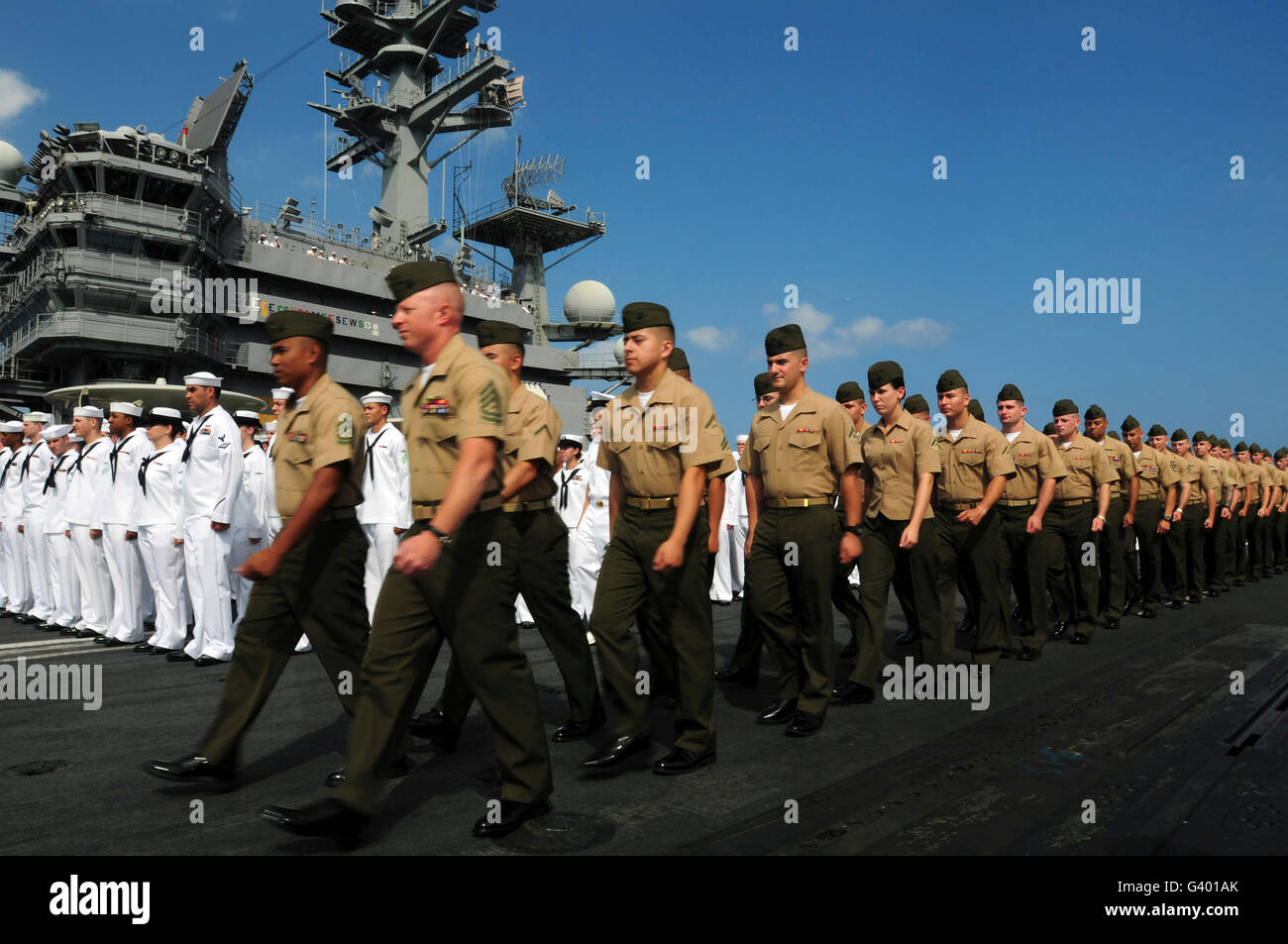 U.S. Marines march in formation to move into position to man the rails with sailors aboard USS Ronald Reagan. Stock Photo