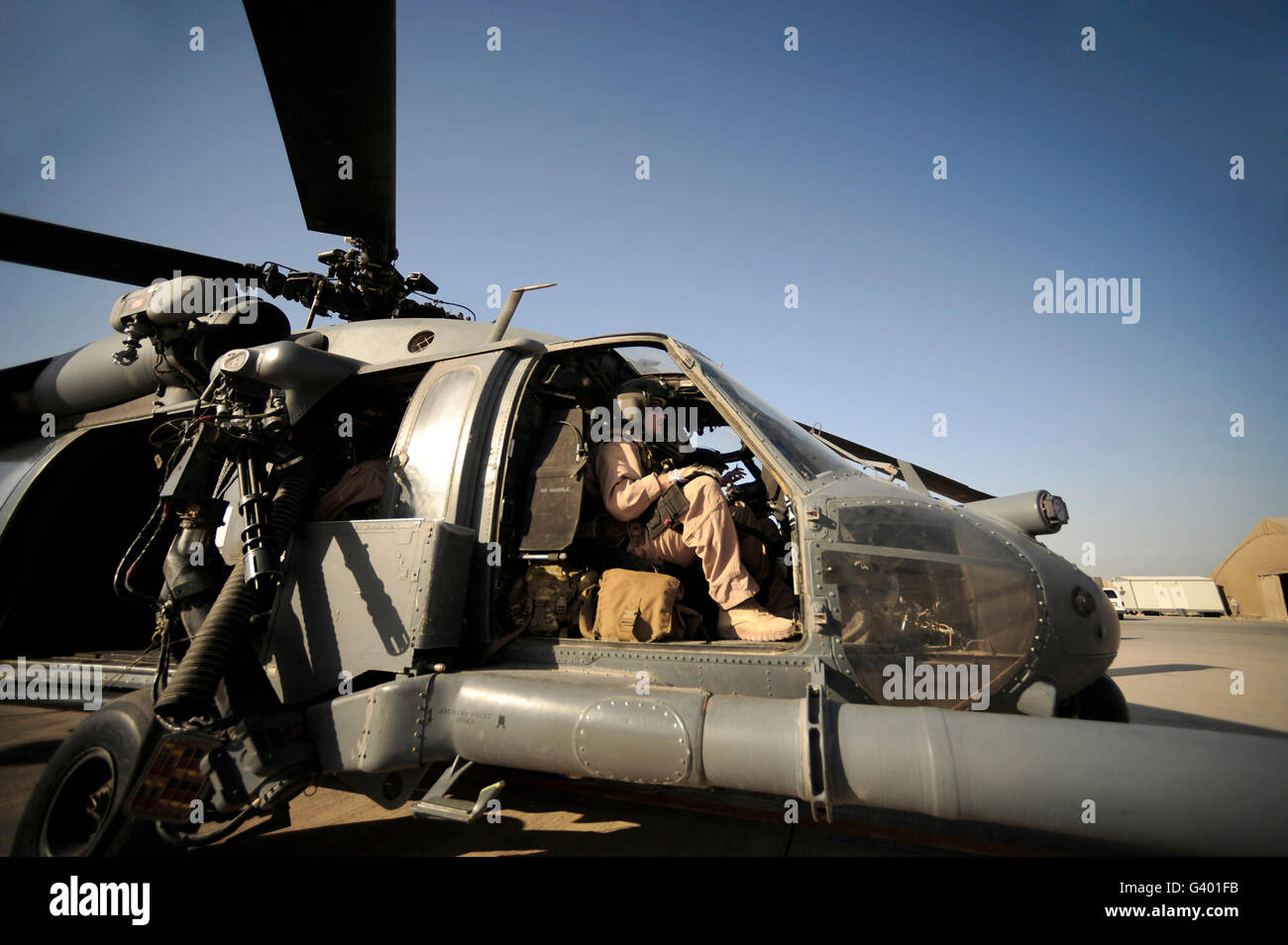 A pilot sits in the cockpit of a HH-60G Pave Hawk. Stock Photo