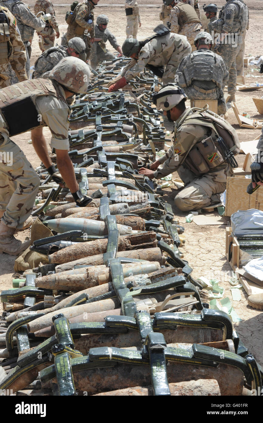 Iraqi soldiers and the U.S. Army place C4 plastic explosives on unexploded ordnance. Stock Photo