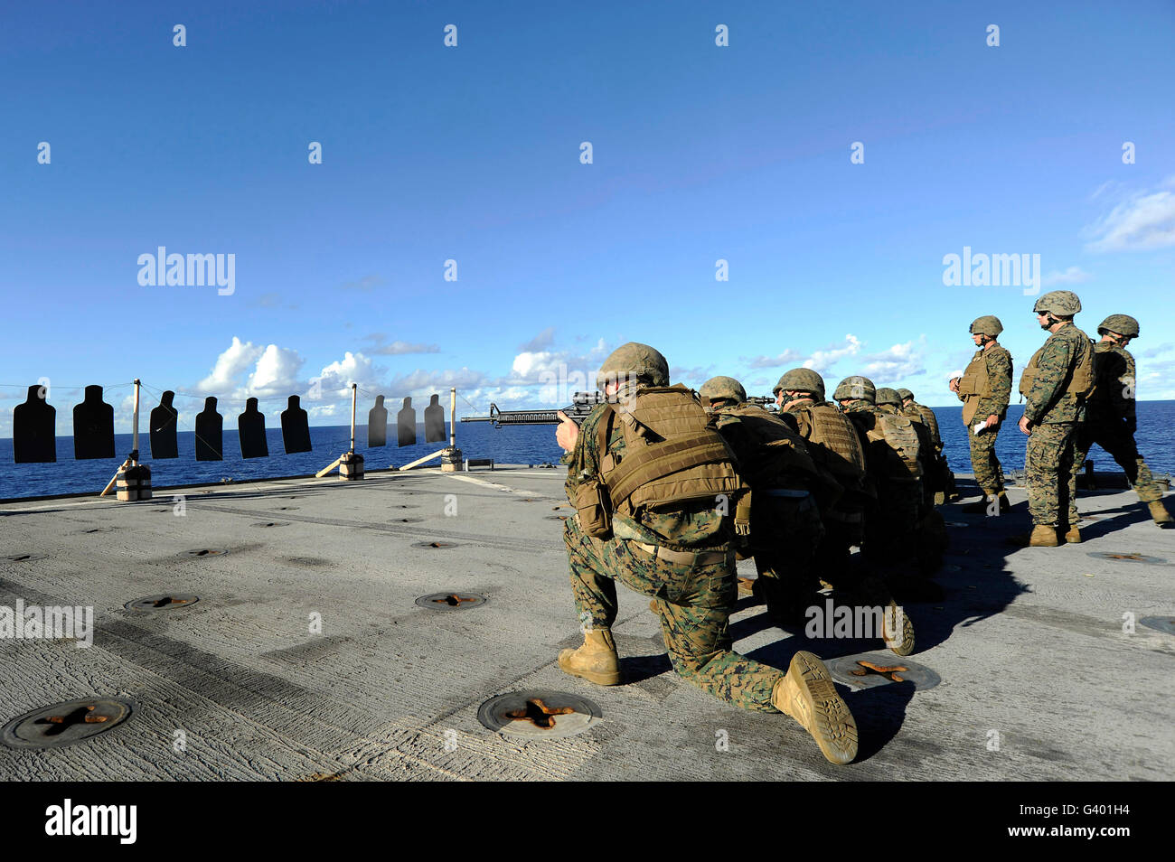 Marines practice shooting their M4 carbines and M16 rifles aboard USS Harpers Ferry. Stock Photo