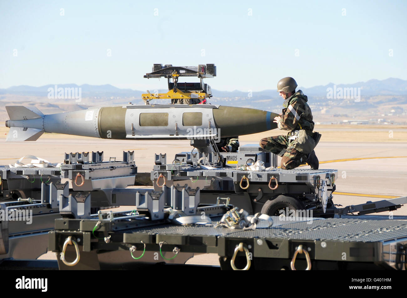 irman assists in lowering a guided bomb unit onto a bomb trailer. Stock Photo