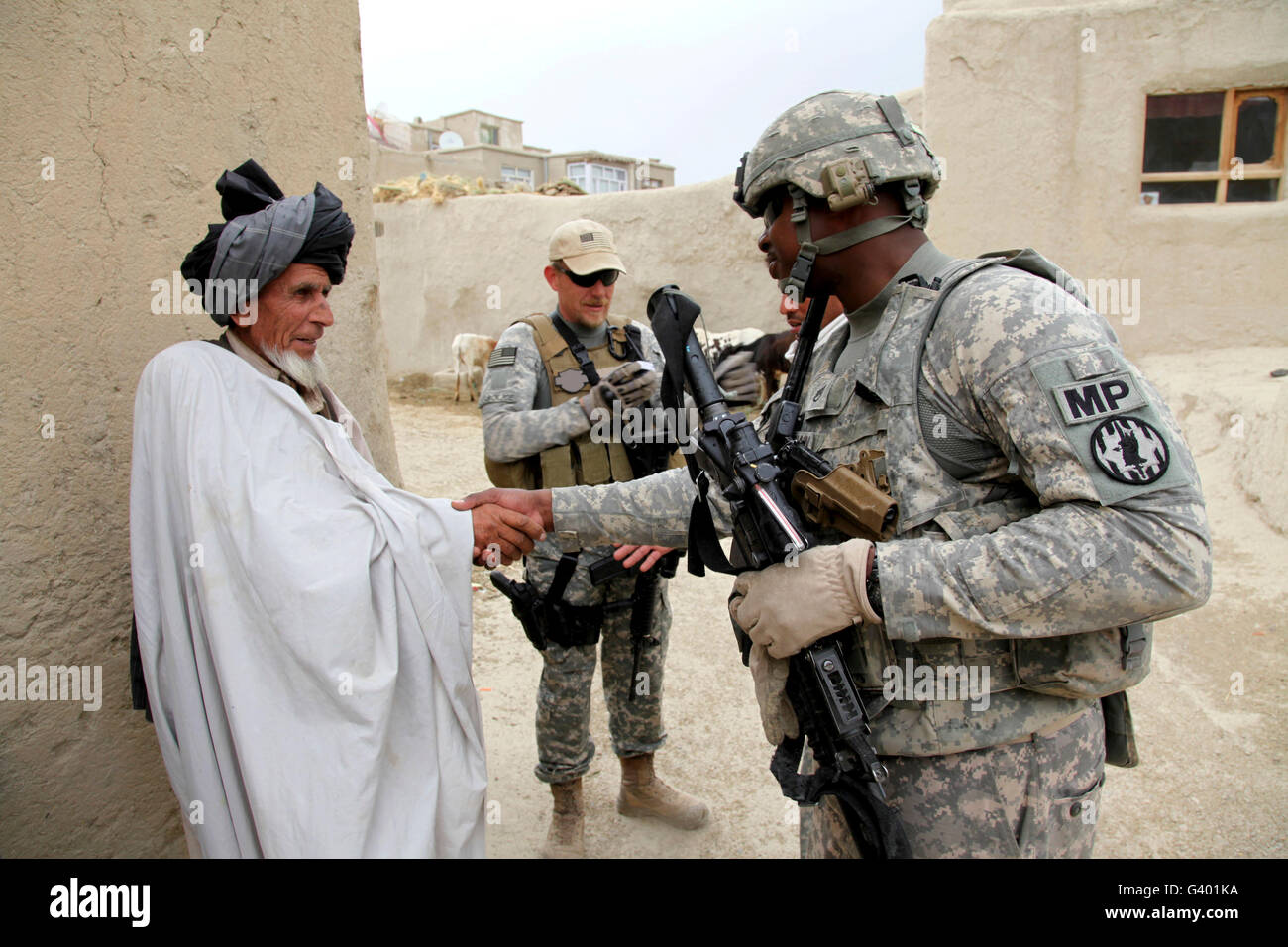 U.S. Army soldier shakes hands with an elder in a village in