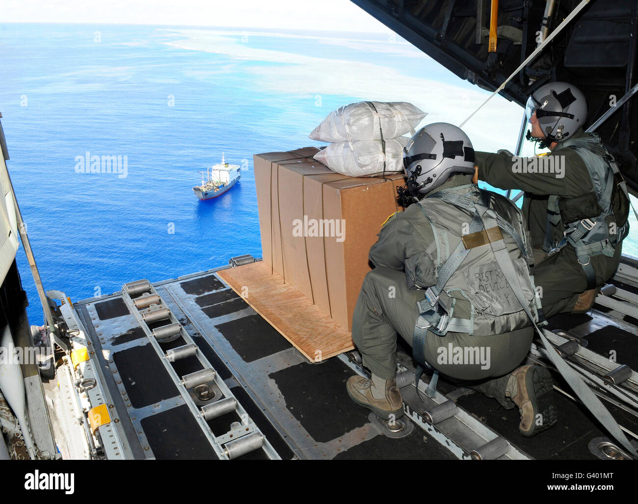 Airmen gauge the distance before pushing humanitarian goods out of a C-130 Hercules. Stock Photo