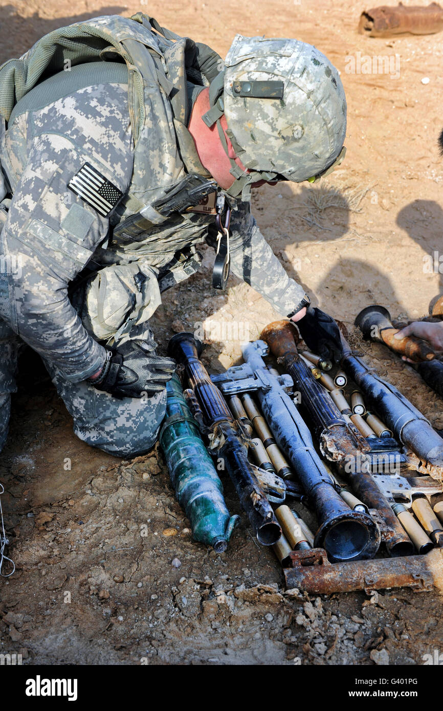 U.S. Army soldier places unexploded ordnance into a pile for disposal. Stock Photo