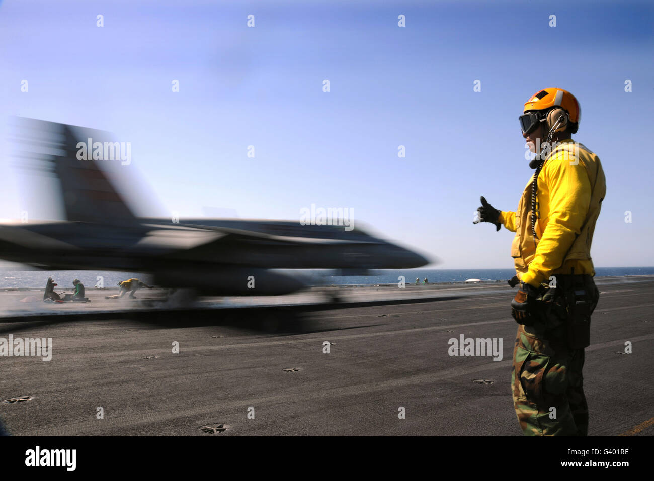 A Sailor ensures an F/A-18C Hornet is ready for launch. Stock Photo