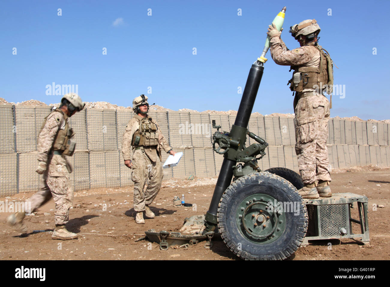 Marines prepare to fire a 120mm mortar.