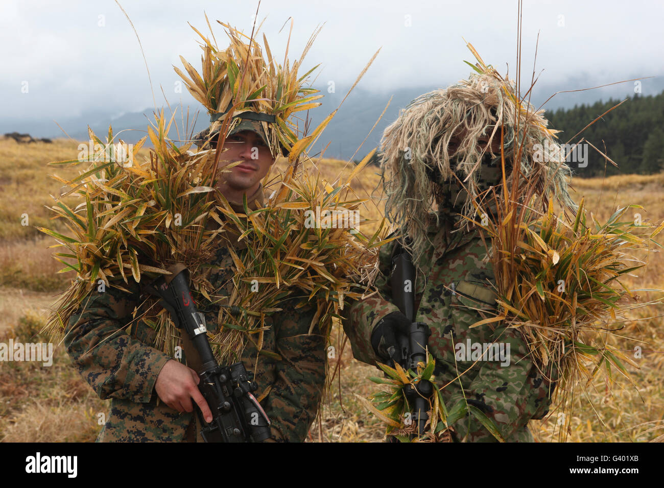 U.S. Marine and Japanese sniper await instructions during a training exercise. Stock Photo