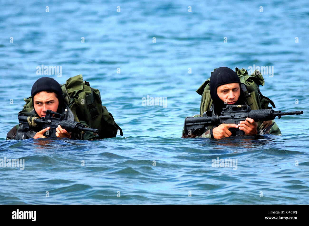 BUD/S students wade ashore during an over the beach exercise.. Stock Photo