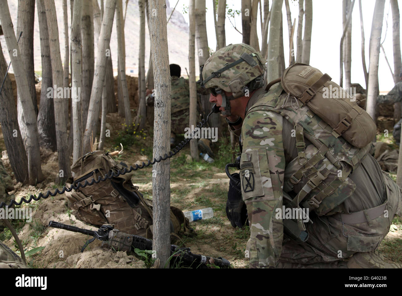 U.S. Army soldier communicates possible enemy locations during combat in Afghanistan. Stock Photo