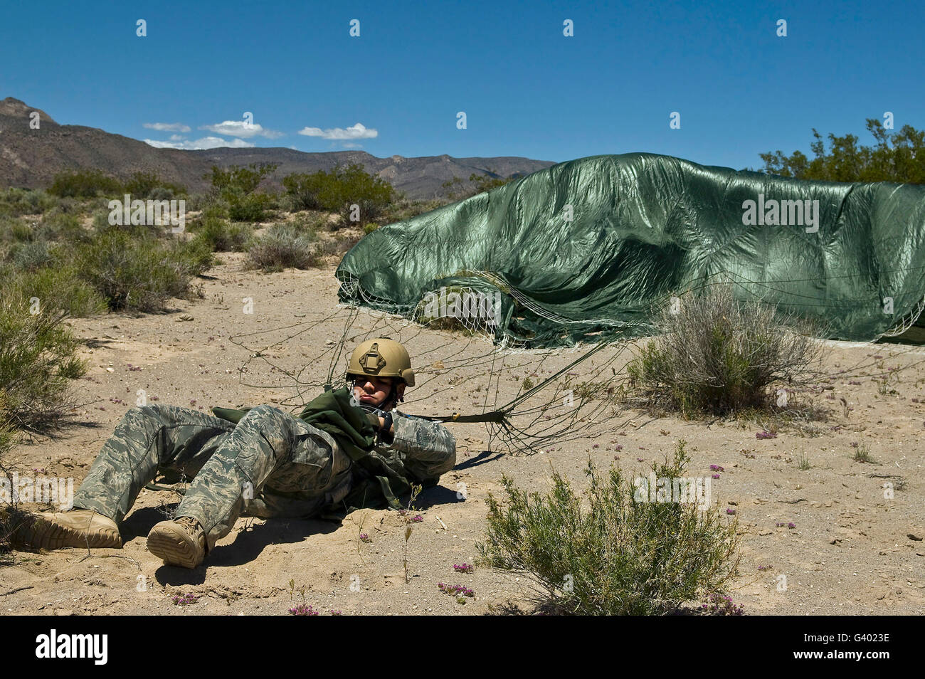 A paratrooper recovers after landing from an air jump. Stock Photo