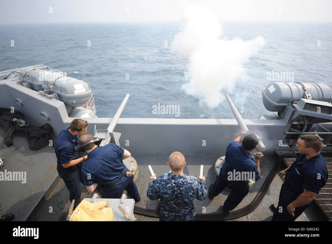 Sailors perform a 21-gun salute aboard USS Dwight D. Eisenhower. Stock Photo