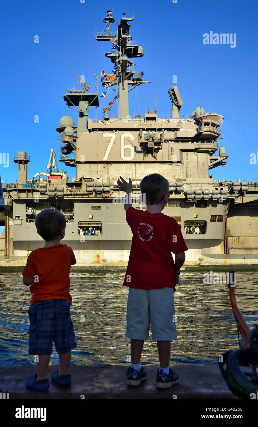 Children wave as USS Ronald Reagan returns for a scheduled port visit. Stock Photo