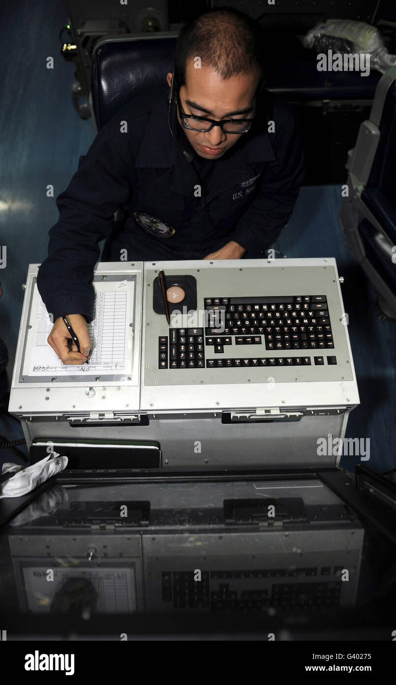 Air Traffic Controller records incoming aircraft inside the control center aboard USS John C. Stennis. Stock Photo