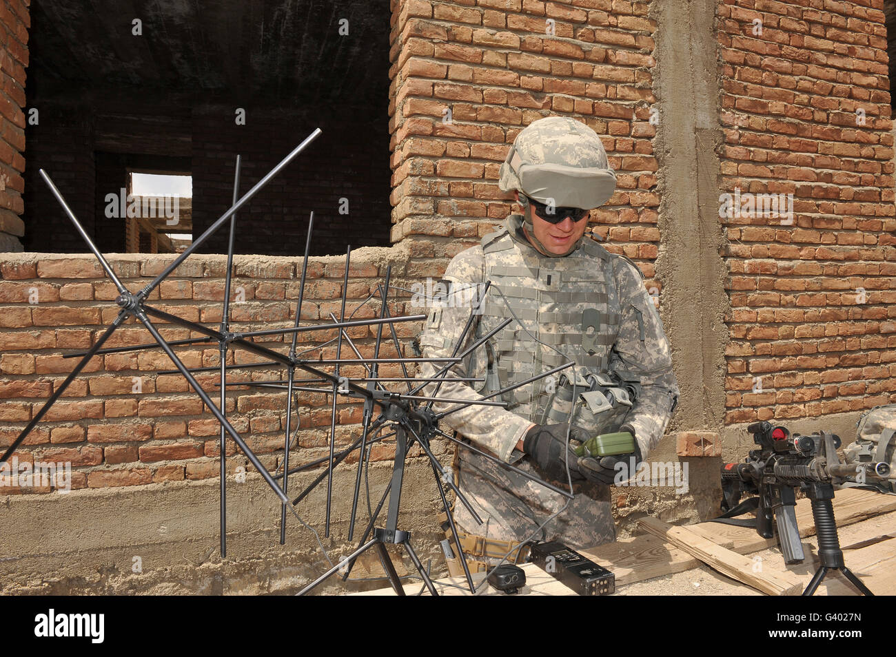 U.S. Army soldier configures a satellite communication device. Stock Photo