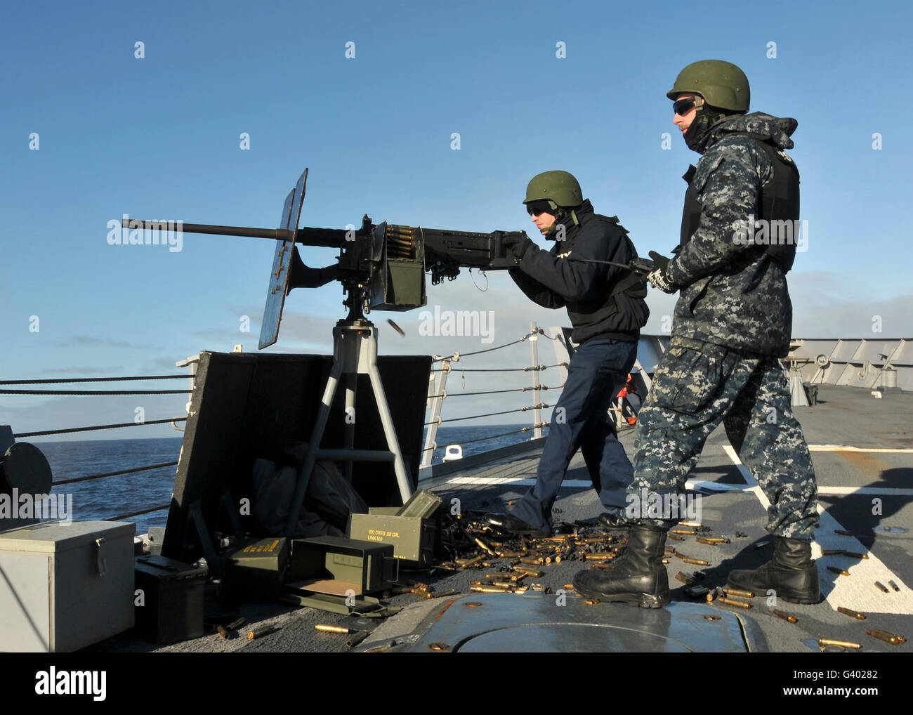Seaman fires a .50 caliber machine gun aboard USS Thach. Stock Photo