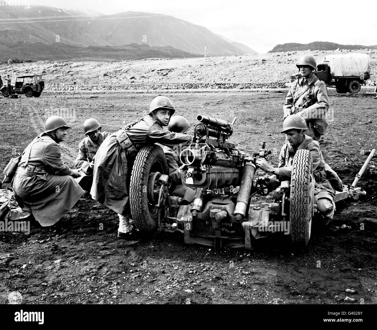 Gun crew prepares to fire a 37mm sub-caliber mounted on a 75mm field howitzer. Stock Photo